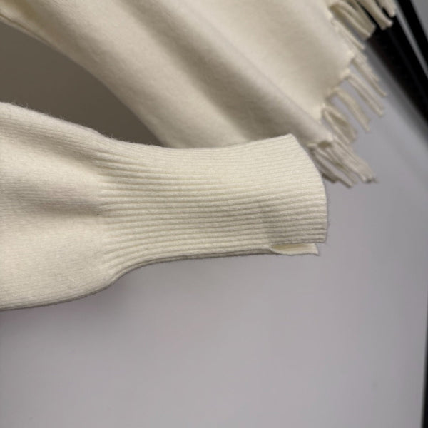Top en maille à manches longues avec pompon et collier doré en métal siglé Chanel