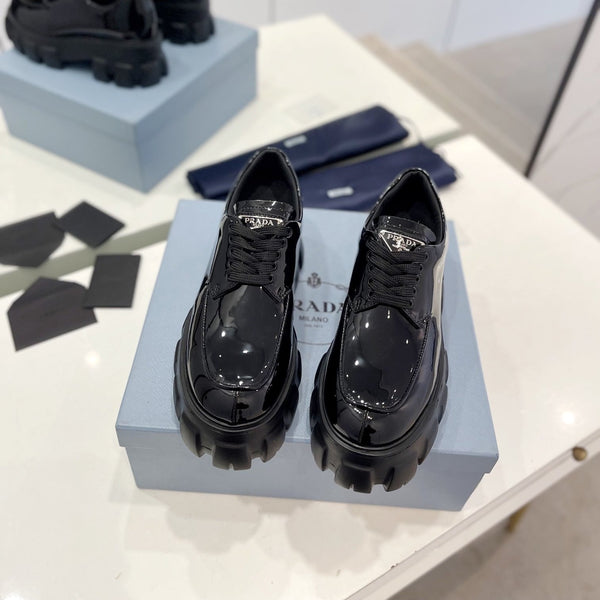 MOCASSINO MONOLITH CON LACCI IN PELLE DI VITELLO NERA LUCIDA CON LOGO TRIANGOLARE APPLICATO