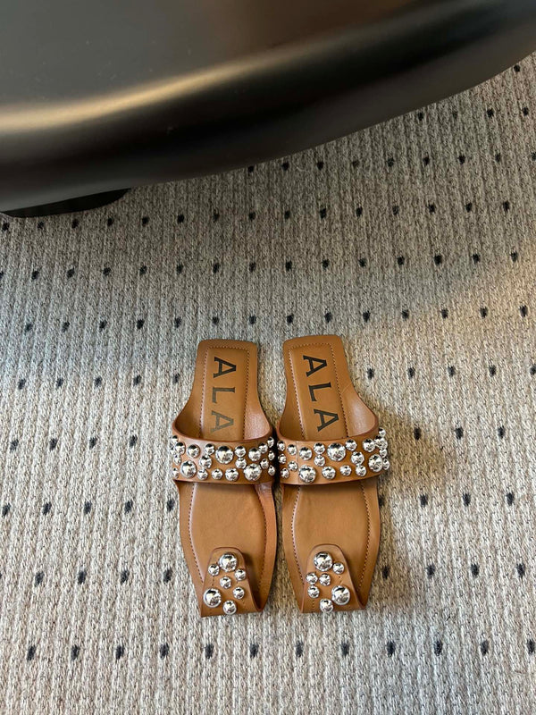 ALAIA FOLDED FLAT MULES WITH SPHERES ON COPPER BROWN CALFSKIN