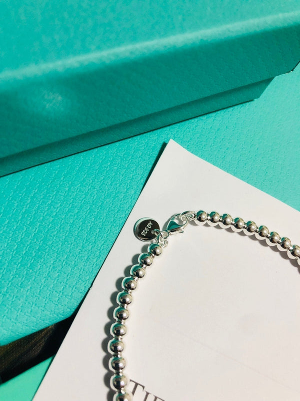 BRACCIALE CON PERLINE E ETICHETTA A CUORE ROSSO TIFFANY
