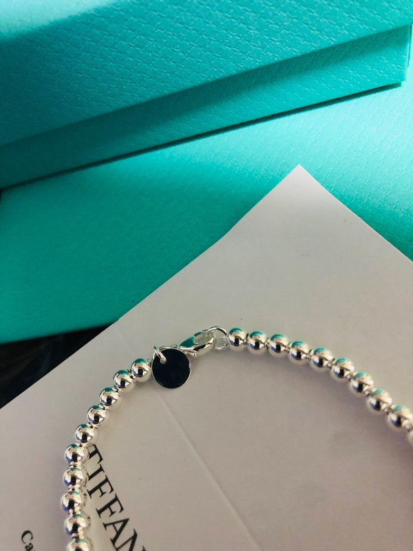 BRACCIALE CON PERLINE E ETICHETTA A CUORE ROSSO TIFFANY