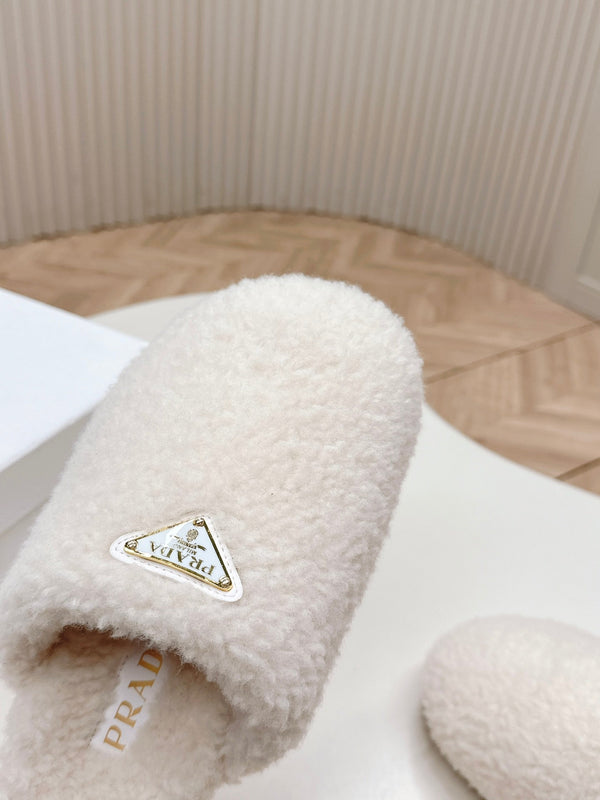 MULES CON LOGO TRIANGOLARE ATTACCATO IN SHEARLING BIANCO