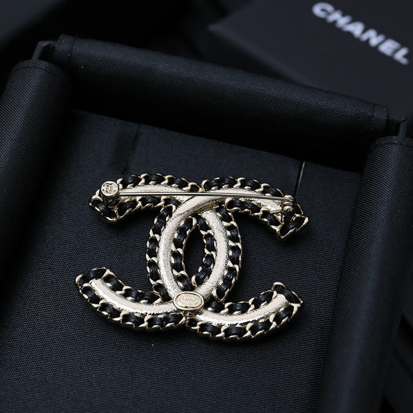 DOUBLE C BROOCH IN GOLD METAL WITH BLACK LEATHER THREADED CHAIN