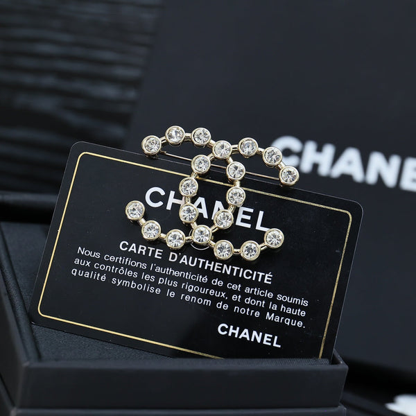 DOUBLE C LETTER BROOCH IN GOLD METAL WITH CRYSTALS AROUND LOGO