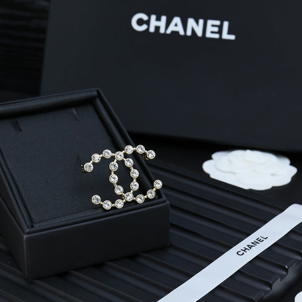 DOUBLE C LETTER BROOCH IN GOLD METAL WITH CRYSTALS AROUND LOGO