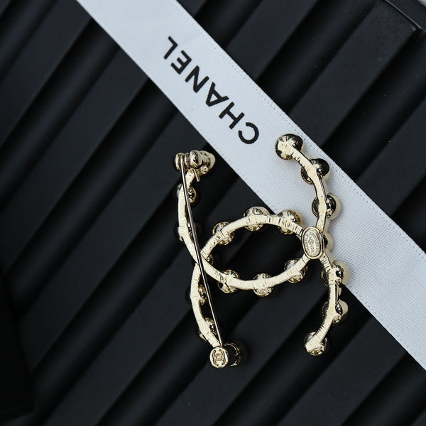 DOUBLE C LETTER BROOCH IN GOLD METAL WITH CRYSTALS AROUND LOGO