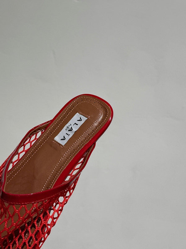 ALAIA FLAT MULES IN CHERRY RED MESH FISHNET
