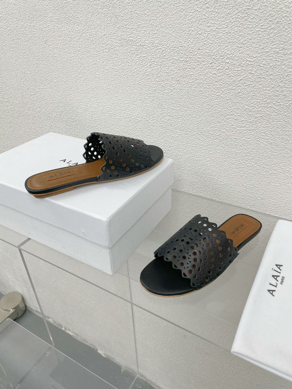ALAIA VIENNE FLAT MULES IN BLACK LAMBSKIN