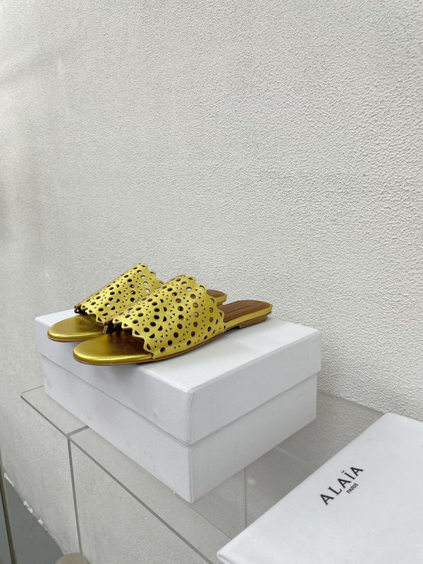 ALAIA VIENNE FLAT MULES IN GOLDEN LAMBSKIN