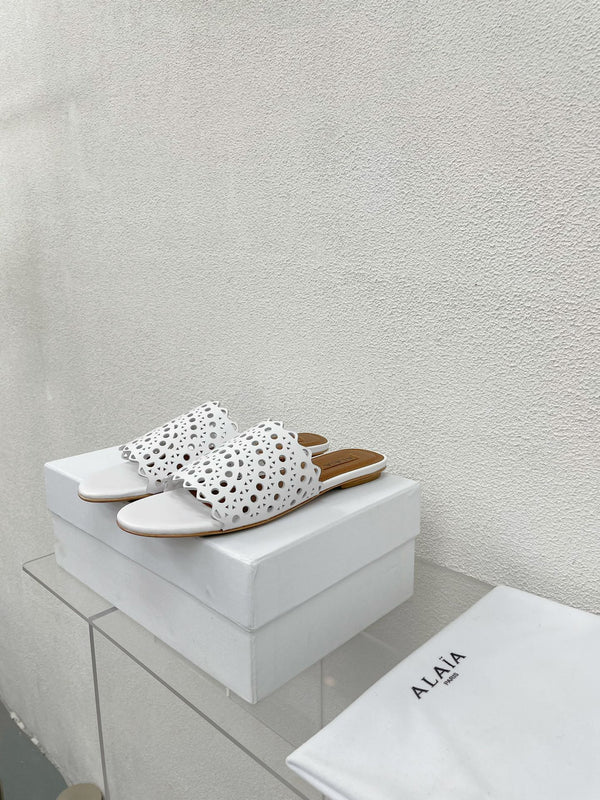 ALAIA VIENNE FLAT MULES IN WHITE LAMBSKIN