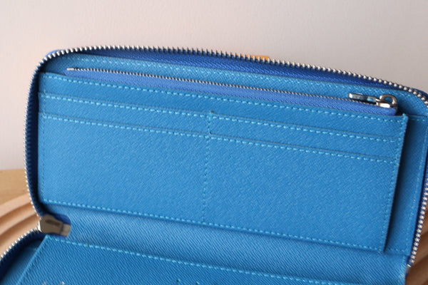 Portafoglio verticale LV Zippy in tela monogramma blu e pelle Taiga 180068