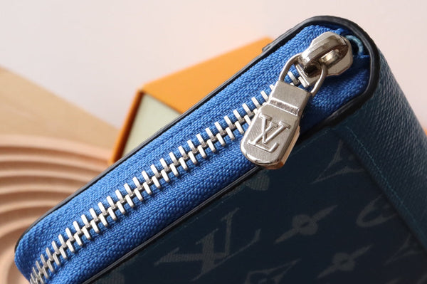 Portafoglio verticale LV Zippy in tela monogramma blu e pelle Taiga 180068