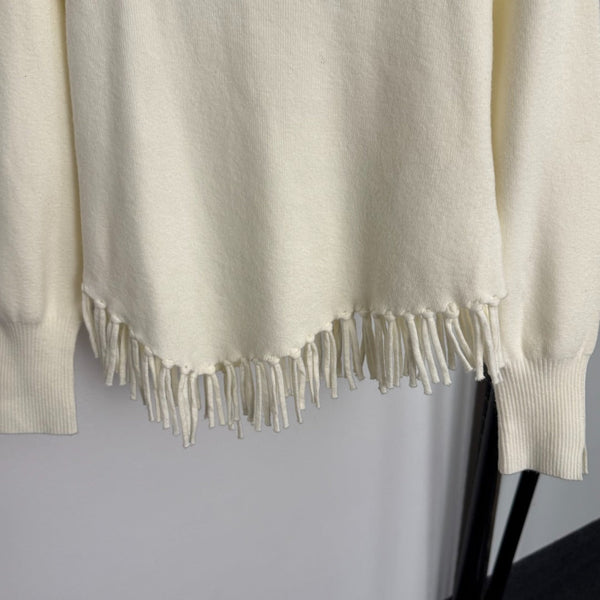 Top en maille à manches longues avec pompon et collier doré en métal siglé Chanel