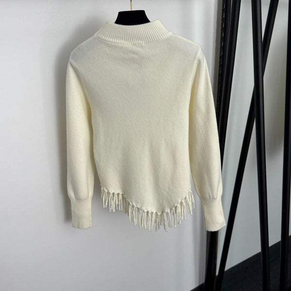 Top en maille à manches longues avec pompon et collier doré en métal siglé Chanel
