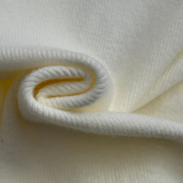 Top en maille à manches longues avec pompon et collier doré en métal siglé Chanel