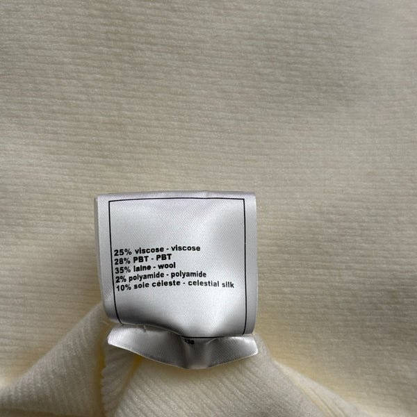 Top en maille à manches longues avec pompon et collier doré en métal siglé Chanel