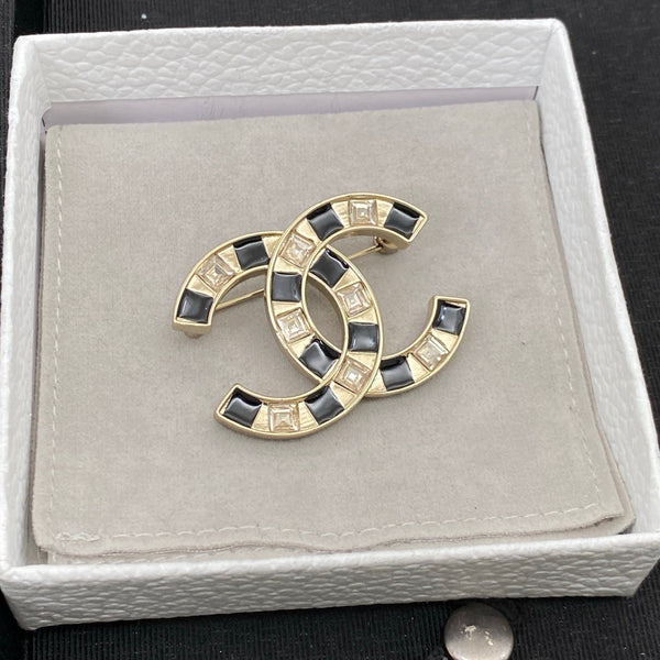 Broche Chanel en résine noire et blanche avec sigle CC