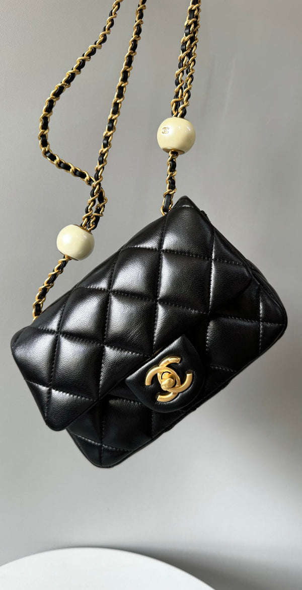Mini borsa con patta 17 cm in pelle di agnello nera con finiture dorate 