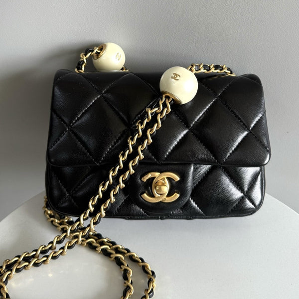Mini borsa con patta 17 cm in pelle di agnello nera con finiture dorate 
