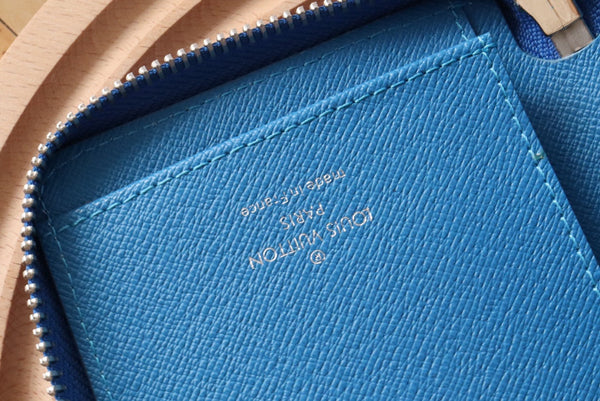 Portafoglio verticale LV Zippy in tela monogramma blu e pelle Taiga 180068