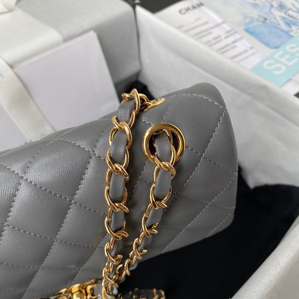Borsa media classica con patta 23 cm in pelle di agnello grigia con finiture dorate 